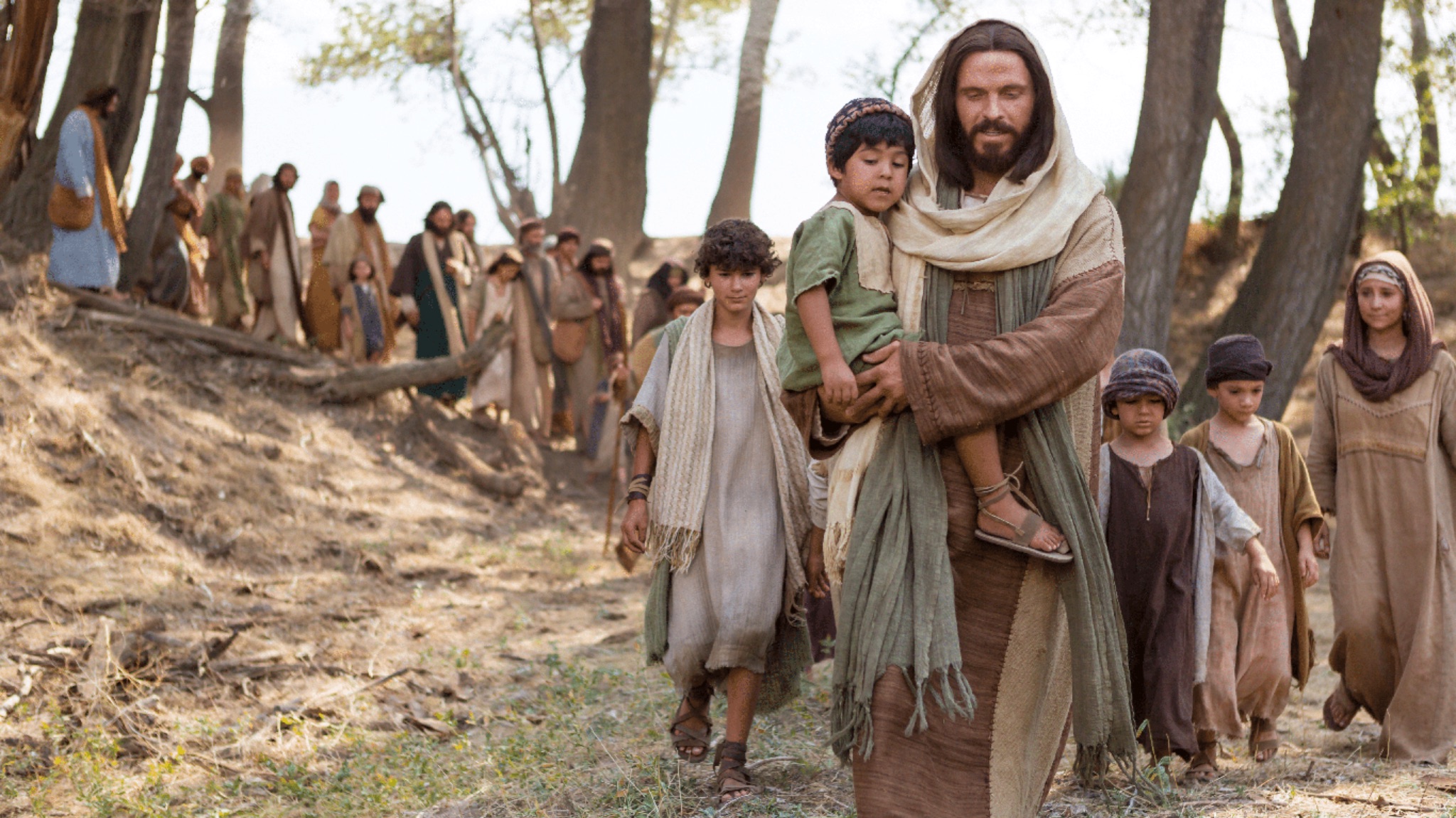 The Savior walking with a group of children, carrying one in his arms
