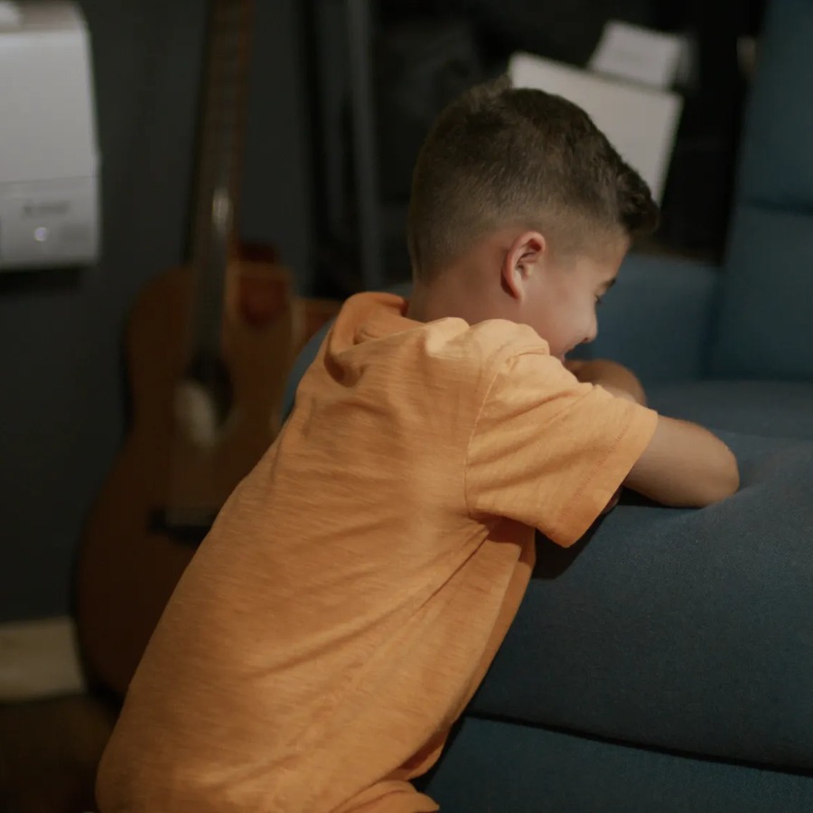 A young boy kneeling in prayer